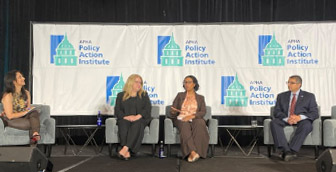 HRSA Administrator Johnson participates in a panel discussion with three others while on stage at a Policy Action Institute event. 
