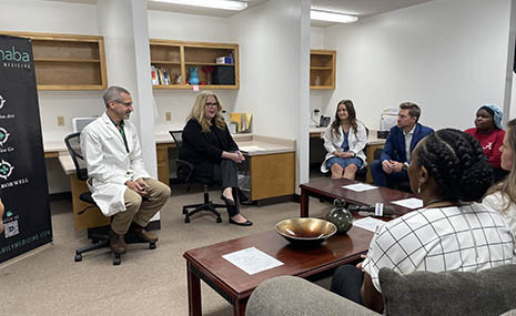 HRSA Administrator Carole Johnson talking with a group of staffers from the Cahaba Medical Care facility in a meeting room. 