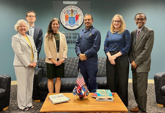 A group photo of six HRSA regional leaders standing together in an office setting. 