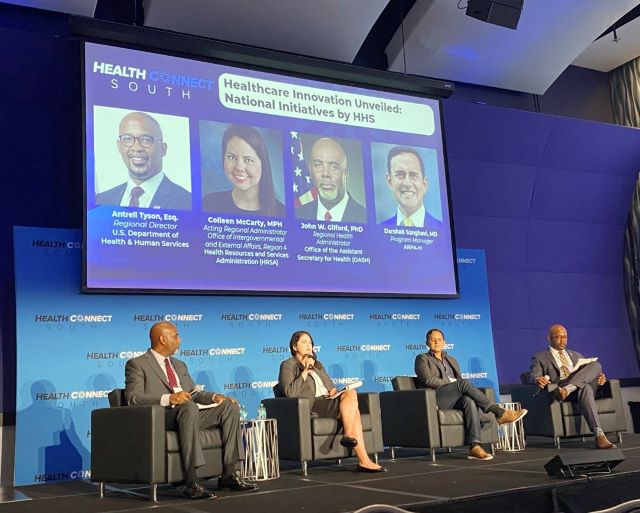 Four panelists are seated on stage during a discussion at Health Connect South’s Annual Gathering, including Colleen McCarty, HRSA IEA Region 4 Acting Regional Administrator. 