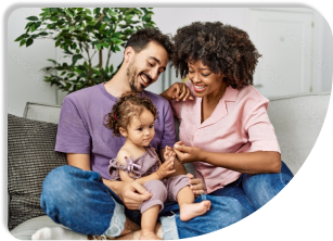 Two people are sitting with their young child on the ground.