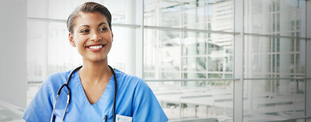 A health professional is facing the camera and smiling.