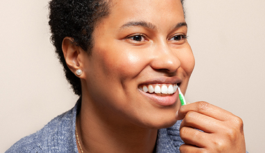 Woman demonstrating use of an interdental brush
