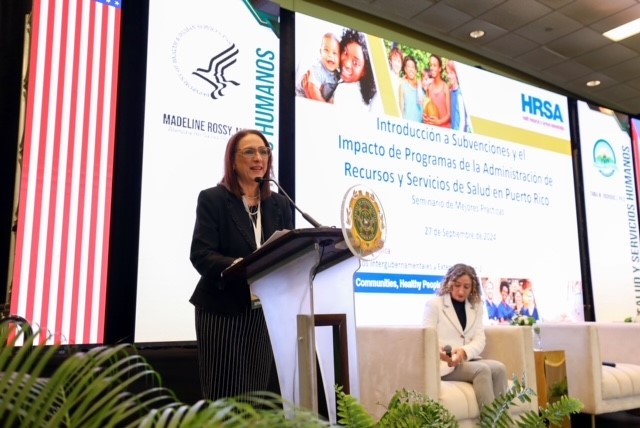 Madeline Rossy (IEA) stands at a podium speaking at the Puerto Rico Best Practices Seminar.