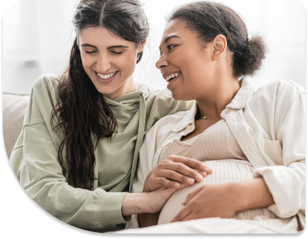 Woman with hand on pregnant woman's baby bump