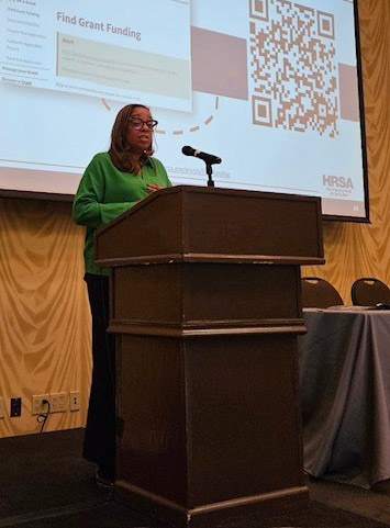 HRSA IEA Public Health Advisor Rhonda Jackson speaking while standing at a podium.