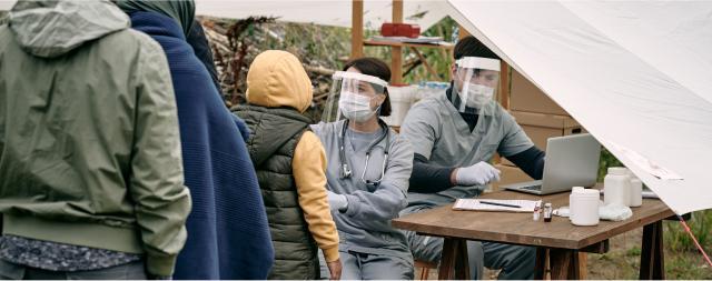 A group of people are waiting in line at a health screening station.