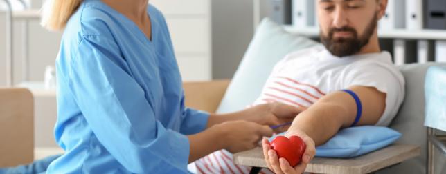 Female nurse preparing a male donor for blood donation  