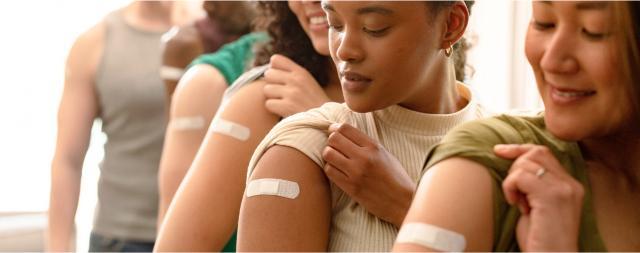 A group of people are showing their arms after receiving a vaccination.